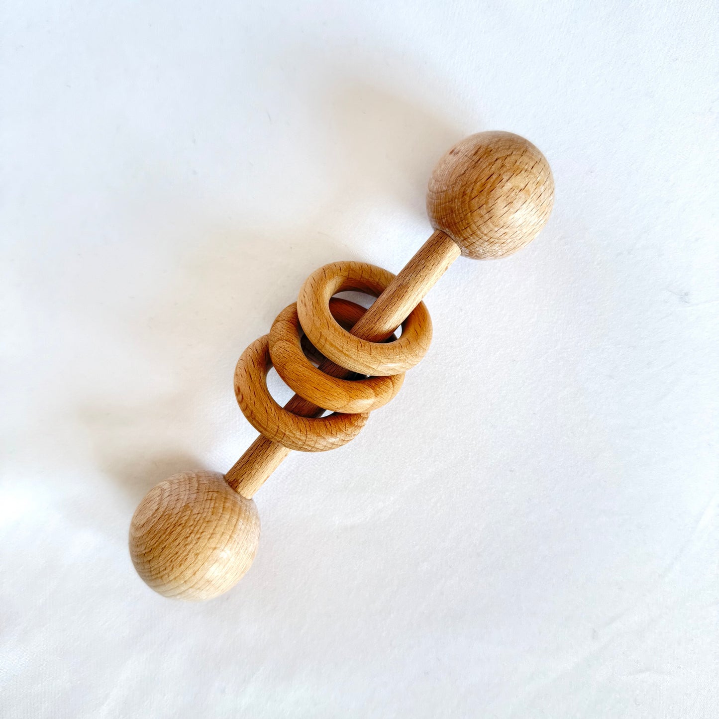 Wooden baby rattle toy on a white background